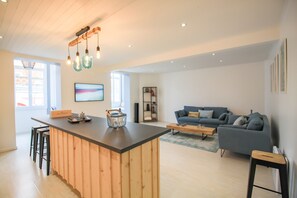 Un salon moderne avec un îlot central en bois, un canapé bleu et une table basse.