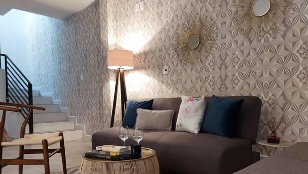 A living room with a sofa, a coffee table, and a chair. There is a staircase in the background. - Enjoy your stay right  in the heart of Morelia (Morelia)