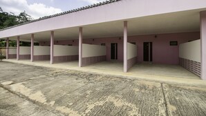 A building with a covered outdoor area, featuring a series of columns and a flat roof. - OYO 75392 Phachuen Resort (Sattahip)