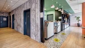 Eine Hotelhalle mit Holzboden, einer Rezeption und einer grünen Wand.