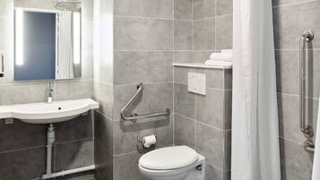 A modern bathroom with a sink, toilet, and shower.