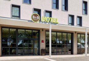 Un hotel B&B con fachada moderna, ventanas amplias y una entrada visible.