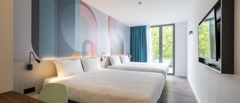 Una habitación de hotel moderna con dos camas, un televisor y un amplio ventanal con cortinas.