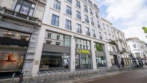 Un hotel con fachada moderna, ventanas grandes y un cartel llamativo que dice 'HOTEL'.