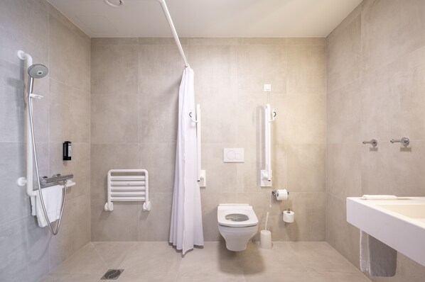 Un baño moderno con ducha, inodoro y lavamanos.