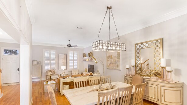 A spacious dining area with a large table, wooden chairs, and a chandelier. - Chic Townhome One Block From Forsyth w/ Large Garage by Lucky Savannah (Savannah)