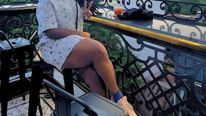 A person sitting on a balcony with a cityscape view. - Hanoi Media Hotel And Spa (Hanoi)