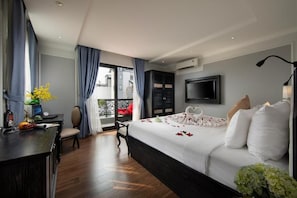 A hotel room with a bed, a desk, a chair, a TV, and a balcony with a view. - Hanoi Media Hotel And Spa (Hanoi)