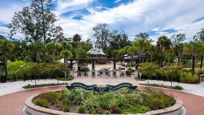 A circular brick pathway leading to a gazebo with a sign reading "Adventure Playground."