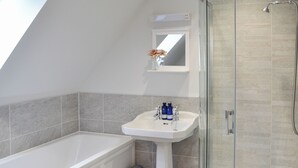 A bathroom with a bathtub, a pedestal sink, and a shower. - Grieve's Cottage - UK11107 (Montrose)