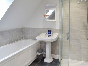 Een badkamer met een bad, een wastafel en een douche.
