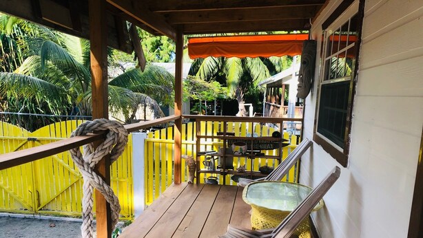Une terrasse en bois avec une clôture jaune, une corde et une chaise.