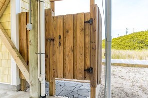 Eine Holzkonstruktion mit einem Metallgitter, einer Betonmauer und einem Pflasterweg.