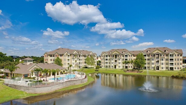 A multi-story hotel with a swimming pool and a lake. - Cane Island (Kissimmee)