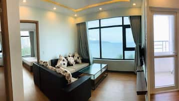 Apartamento superluxo, 2 quartos, vista para o mar | Área de estar | TV LCD 40 polegadas com canais a cabo, TV