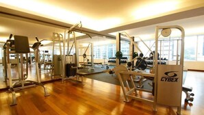 A gym with various exercise machines, a wooden floor, and large windows. - A Best Seri Bukit Ceylon Serviced Residence (Kuala Lumpur)