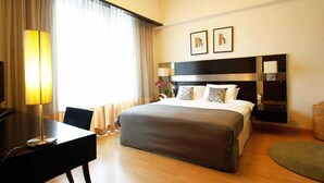 A hotel room with a bed, a desk, a lamp, and a large window with curtains. - A Best Seri Bukit Ceylon Serviced Residence (Kuala Lumpur)