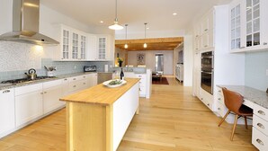 A modern kitchen with white cabinetry, a wooden island, and a central island with a sink. - 3 Bedroom, 3 Bath Home plus 1 Bedroom, 1 Bath Casita -12 min. to Santa Fe center (Santa Fe)