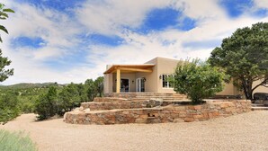 A modern house with a stone staircase leading to a wooden porch, surrounded by trees and a clear sky. - 3 Bedroom, 3 Bath Home plus 1 Bedroom, 1 Bath Casita -12 min. to Santa Fe center (Santa Fe)