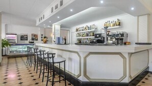 A bar area with a counter, stools, and a display case. - Apartamentos San Antonio Beach (Sant Josep de sa Talaia)