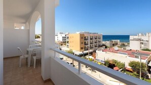 A balcony with a view of the sea and buildings. - Apartamentos San Antonio Beach (Sant Josep de sa Talaia)