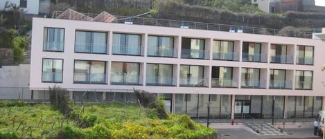 A multi-story building with large windows and balconies.