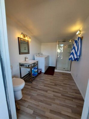 A compact bathroom with a toilet, sink, and shower area.