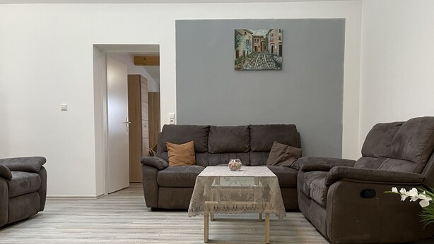 Una sala de estar con un sofá, una mesa de centro y un cuadro en la pared.