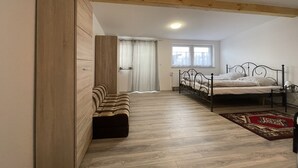 Un dormitorio con una cama, un banco y una ventana.