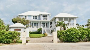 A two-story house with a covered porch and a separate building with a balcony.