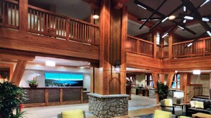 Eine geräumige Lobby mit Holzelementen, einem Steinkamin und gemütlichen Sitzbereichen.