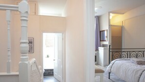Une chambre à coucher comprenant un lit, une chaise, une armoire et une porte donnant sur un balcon.