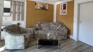 Una sala de estar con sofá, sillón y una mesa de centro.