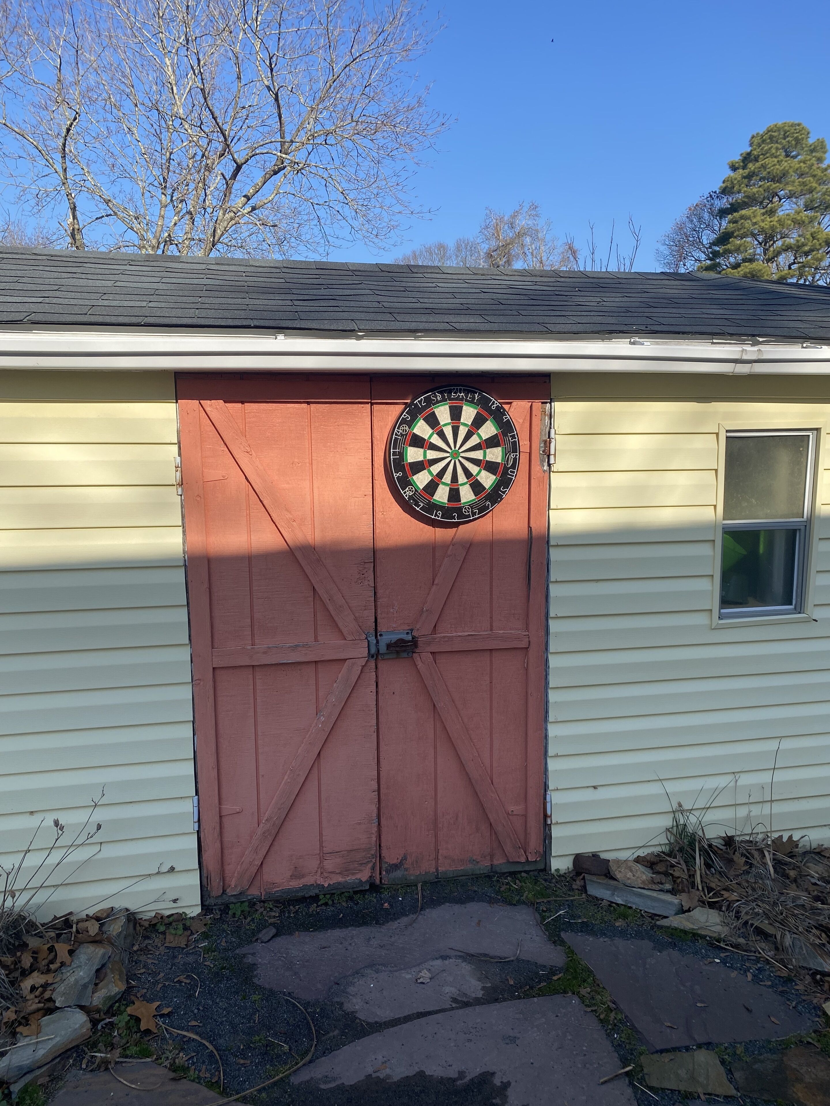 A garage with a dartboard mounted on the door.