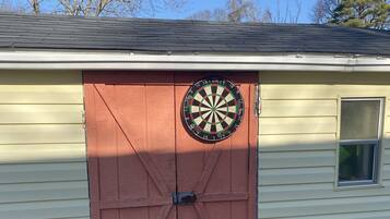A garage with a dartboard mounted on the door.