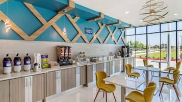 Een moderne keuken met een aanrecht, koffiezetapparaat en uitzicht op het omliggende landschap.