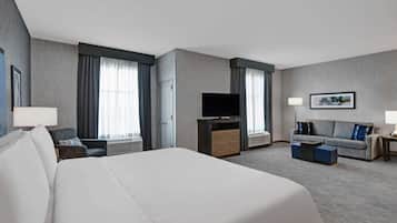Ett hotellrum med en stor säng, en tv, en soffa och ett skrivbord.