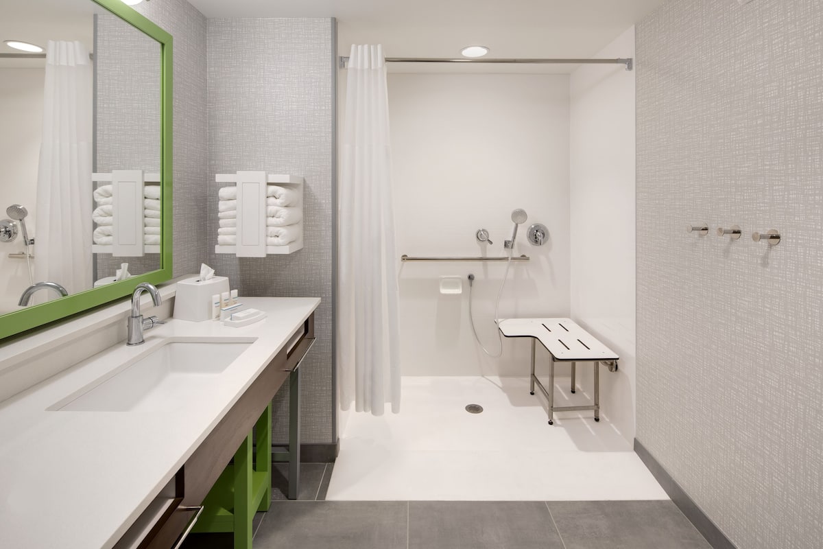 Ein modernes Badezimmer mit Waschbecken, Spiegel und Dusche.