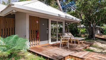 A modern house with a wooden deck, a glass door, and a number 107 sign.