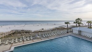 A pool area with lounge chairs and a view of the beach. - Pelican Pointe 504 by Liquid Life (Orange Beach)