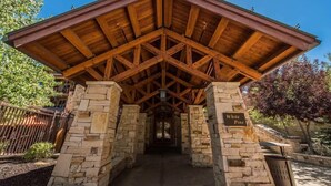 A covered pavilion with a stone base and a wooden roof, labeled "White Pine." - Hyatt at the Canyons by Park City Vacations (Park City)