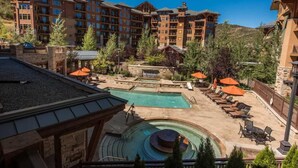 A resort with multiple buildings, a pool area with lounge chairs, and a hot tub. - Hyatt at the Canyons by Park City Vacations (Park City)
