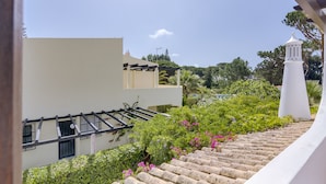 A stone staircase leading up to a white building with a balcony.