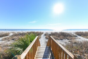 A wooden boardwalk leading to a beach with sand dunes and a clear blue sky. - Oceanfront 5 BR Beach House with a Private Pool! Tranquility (Surfside Beach)