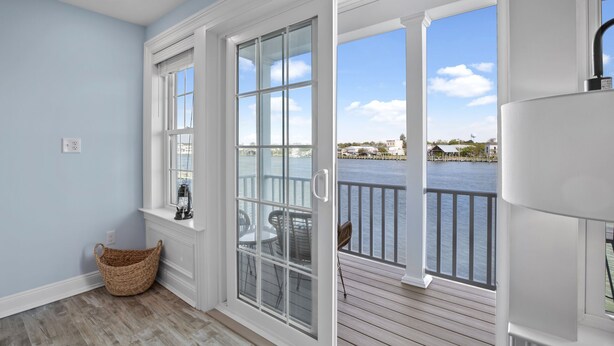 A room with a view of a body of water, a wicker basket, and a white ceiling. - At the Water's Edge by Seaside Vacations & Sales (Chincoteague Island)