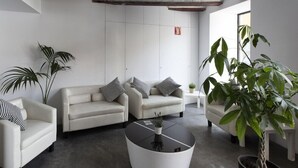 A modern living room with two sofas, a coffee table, and several potted plants. - Dingdong Nuns (Valencia)