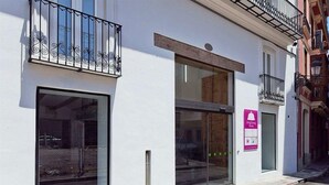 A building with large windows, a visible entrance, and a sign indicating a nursing service. - Dingdong Nuns (Valencia)