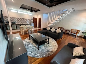 A modern living space with a staircase, a dining area, and a kitchen. - Airis Sanctuary Resort (Langkawi)