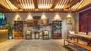 A reception area with wooden furniture, a reception desk, and various decorative items on the walls.