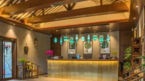 A reception area with a wooden ceiling, a reception desk, and decorative wall art.